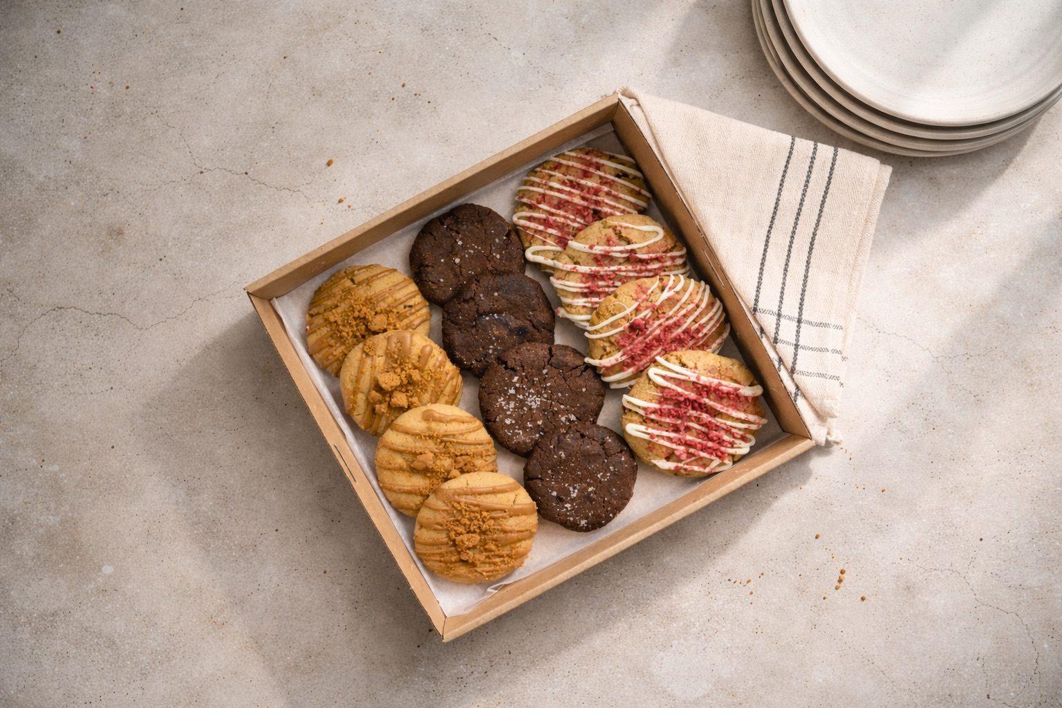 A catering box filled with assorted decorated cookies.